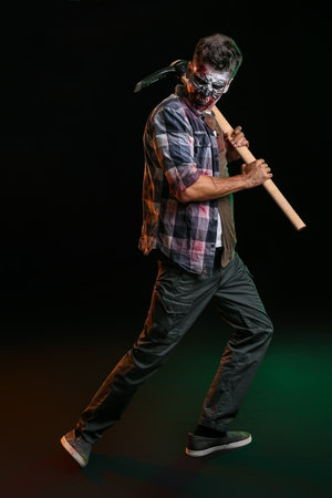 Scary zombie with pick-axe on dark backgroundの写真素材