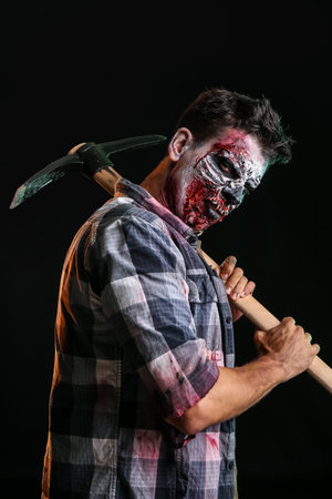 Scary zombie with pick-axe on dark backgroundの写真素材