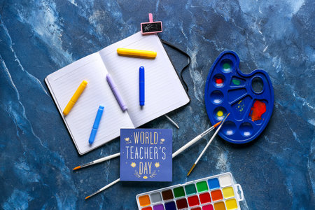 World Teacher's Day. Drawing supplies and greeting card on dark blue background, top viewの写真素材