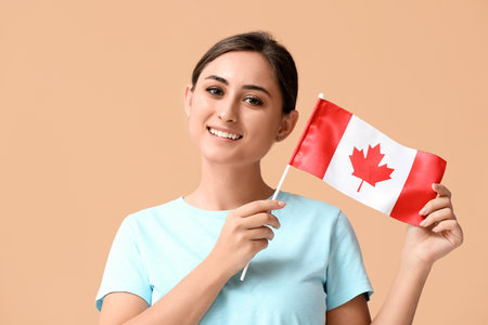 Young woman with national flag of Canada on color backgroundの写真素材