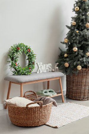 Beautiful mistletoe wreath with Christmas tree bench in interior of roomの写真素材