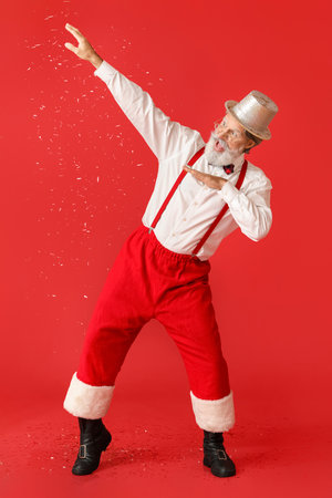 Dancing Santa Claus and falling confetti on color backgroundの写真素材
