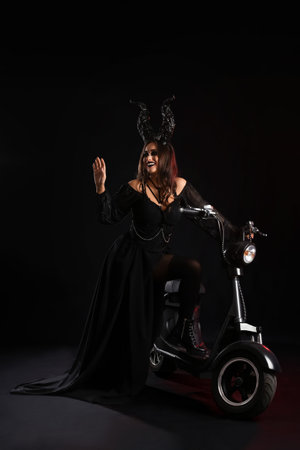 Woman dressed for Halloween with motorcycle on dark backgroundの写真素材