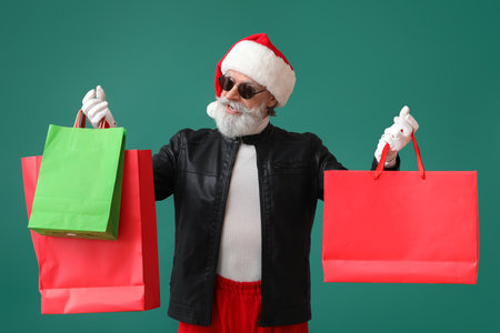 Cool Santa Claus in leather jacket and with shopping bags on color backgroundの写真素材