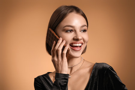 Beautiful woman with sweet chocolate on color background