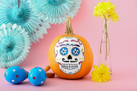 Pumpkin with painted skull on color background. Celebration of Mexico's Day of the Dead (El Dia de...