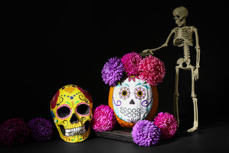 Pumpkin with painted skull on dark background. Celebration of Mexico's Day of the Dead (El Dia de...