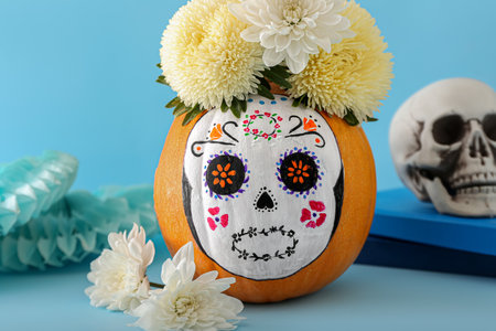 Pumpkin with painted skull on color background. Celebration of Mexico's Day of the Dead (El Dia de...