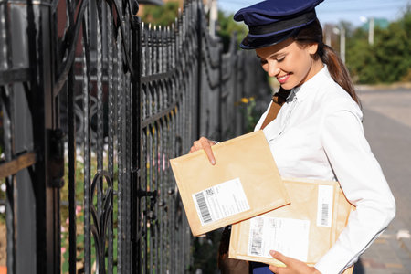 Beautiful postwoman with letters outdoors