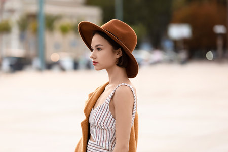 Young fashionable woman in felt hat on city streetの写真素材