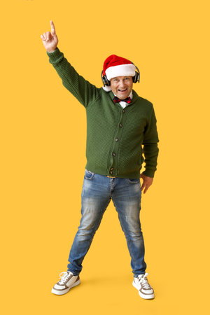Mature man listening to Christmas music on color backgroundの写真素材