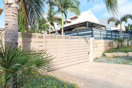 View of modern gate and palm trees on street