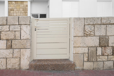 View of stone fence with white door outdoors