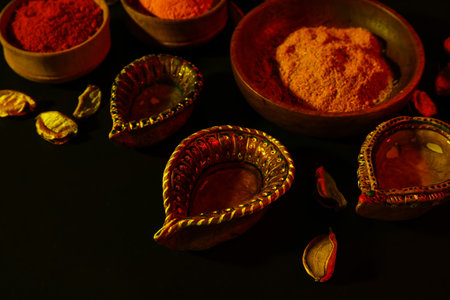 Diya lamps for Diwali with color powder on dark background
