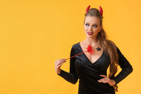 Sexy young woman dressed for Halloween party on color background