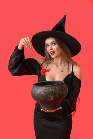 Sexy young witch with cauldron on color backgroundの写真素材