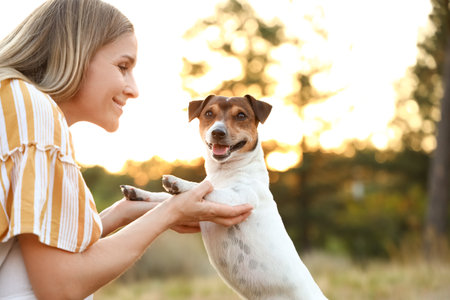 Young woman with cute Jack Russel terrier in parkの写真素材