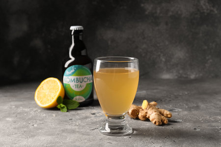 Glass of tasty kombucha with lemon and ginger on tableの写真素材