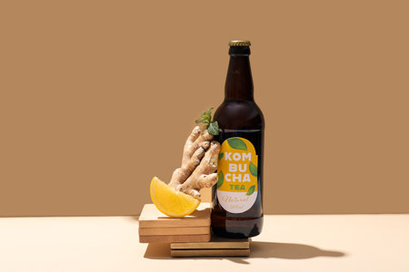 Bottle of tasty kombucha with lemon, ginger and mint on tableの写真素材