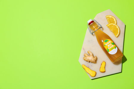 Bottle of tasty kombucha with ginger and lemon on color backgroundの写真素材