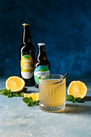 Glass and bottles of natural kombucha on color backgroundの写真素材