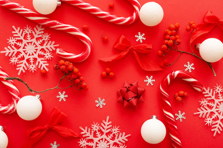 Composition with beautiful Christmas decorations and rowan berries on red backgroundの写真素材
