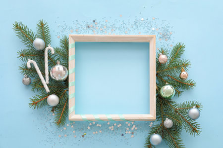 Composition with empty picture frame, fir branches and decorations on color backgroundの写真素材