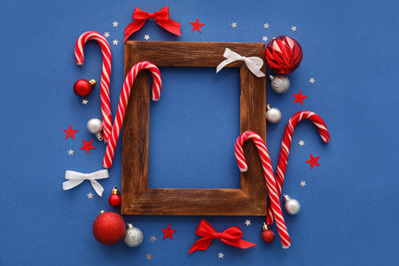 Composition with empty picture frame and Christmas decorations on color backgroundの写真素材