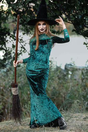 Beautiful young witch in forestの写真素材
