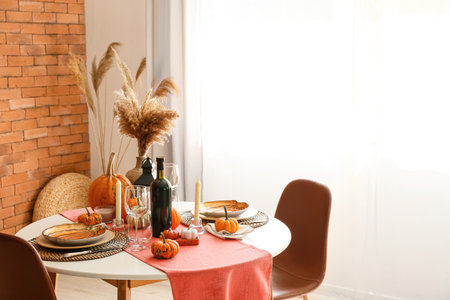 Dining table with pumpkins near window in roomの写真素材