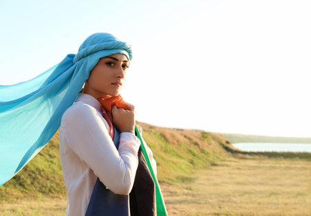 Muslim woman with flag of Afghanistan outdoors