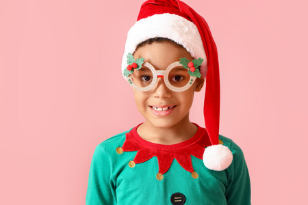 Little African-American boy in Christmas costume on pink backgroundの写真素材