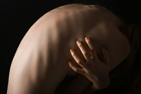 Back of woman on dark background. anorexia concept