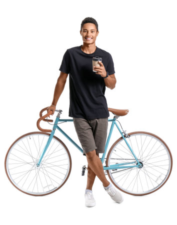 African-American teenage boy with cup of coffee and bicycle on white backgroundの写真素材