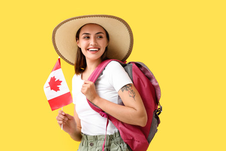 Female tourist with flag of Canada on color backgroundの写真素材