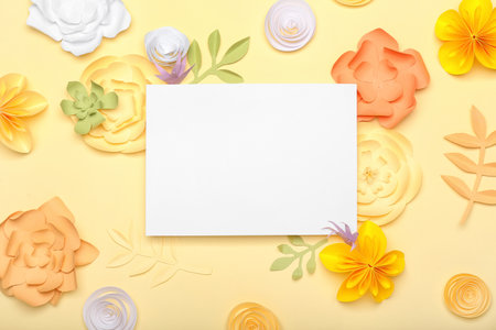 Beautiful handmade paper flowers and blank paper sheet on beige backgroundの写真素材