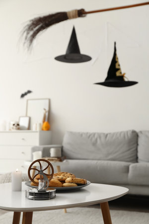 Table with tasty cookies and decor in room decorated for Halloweenの写真素材