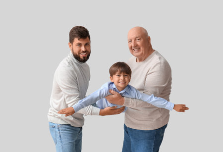 Happy man, his little son and father on light backgroundの写真素材