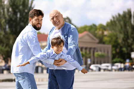 Happy man, his little son and father walking outdoorsの写真素材