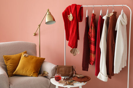 Rack with warm sweaters in interior of stylish roomの写真素材
