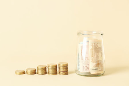 Jar of euro banknotes and coins on beige background. budget conceptの写真素材