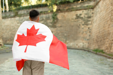 Young man with flag of Canada outdoorsの写真素材