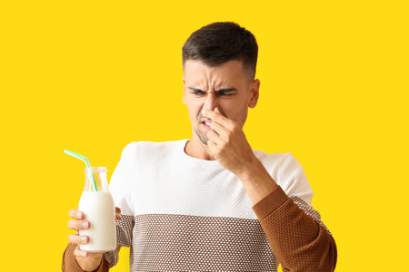 Young man with lactose intolerance on color backgroundの写真素材