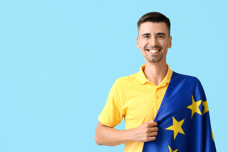 Young man with flag of European Union on color background