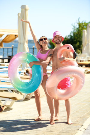 Young couple with inflatable rings at sea resortの写真素材