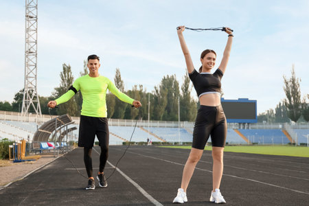 Sporty young couple with skipping ropes training in the stadiumの写真素材