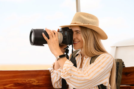 Beautiful female tourist with photo camera on safari
