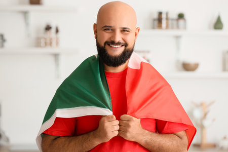 Handsome man with flag of Mexico at homeの写真素材