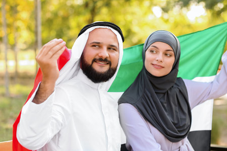 Couple in traditional clothes and with the national flag of UAE outdoorsの写真素材