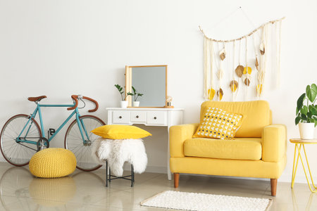 Interior of light room with yellow armchair, dressing table and bicycleの写真素材